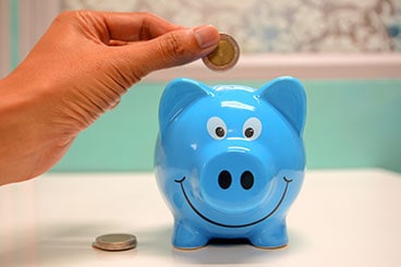 Saving money in a blue piggy bank