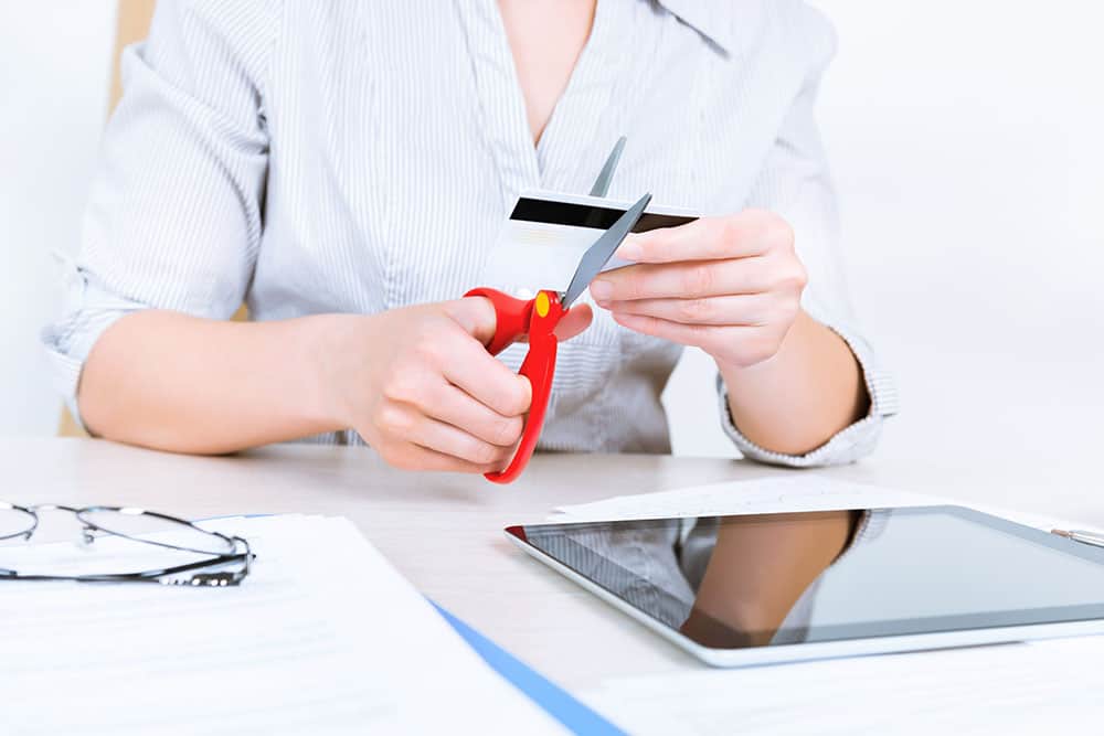 Woman cutting credit card with scissors after not wanting any further debt