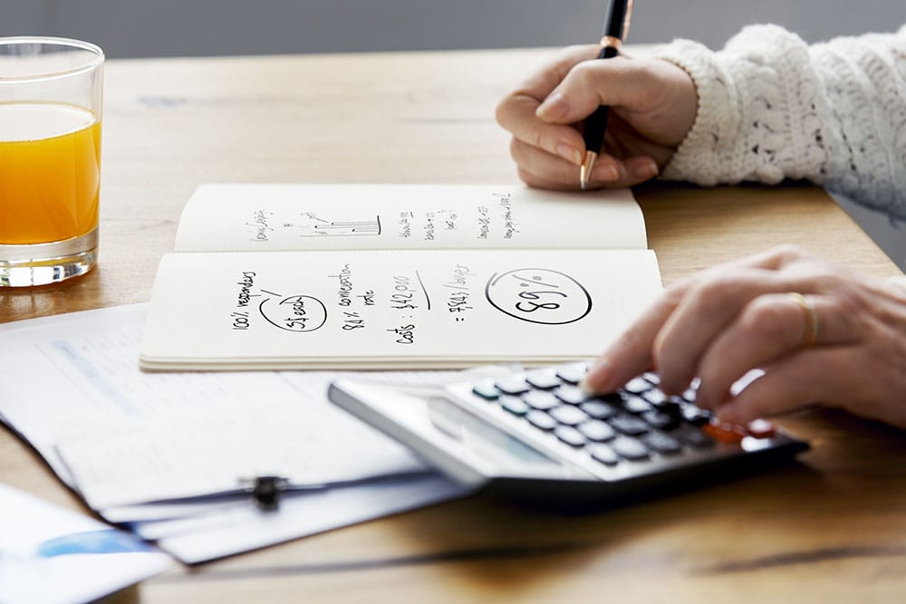 Girl typing into a calculator creating a personal budget